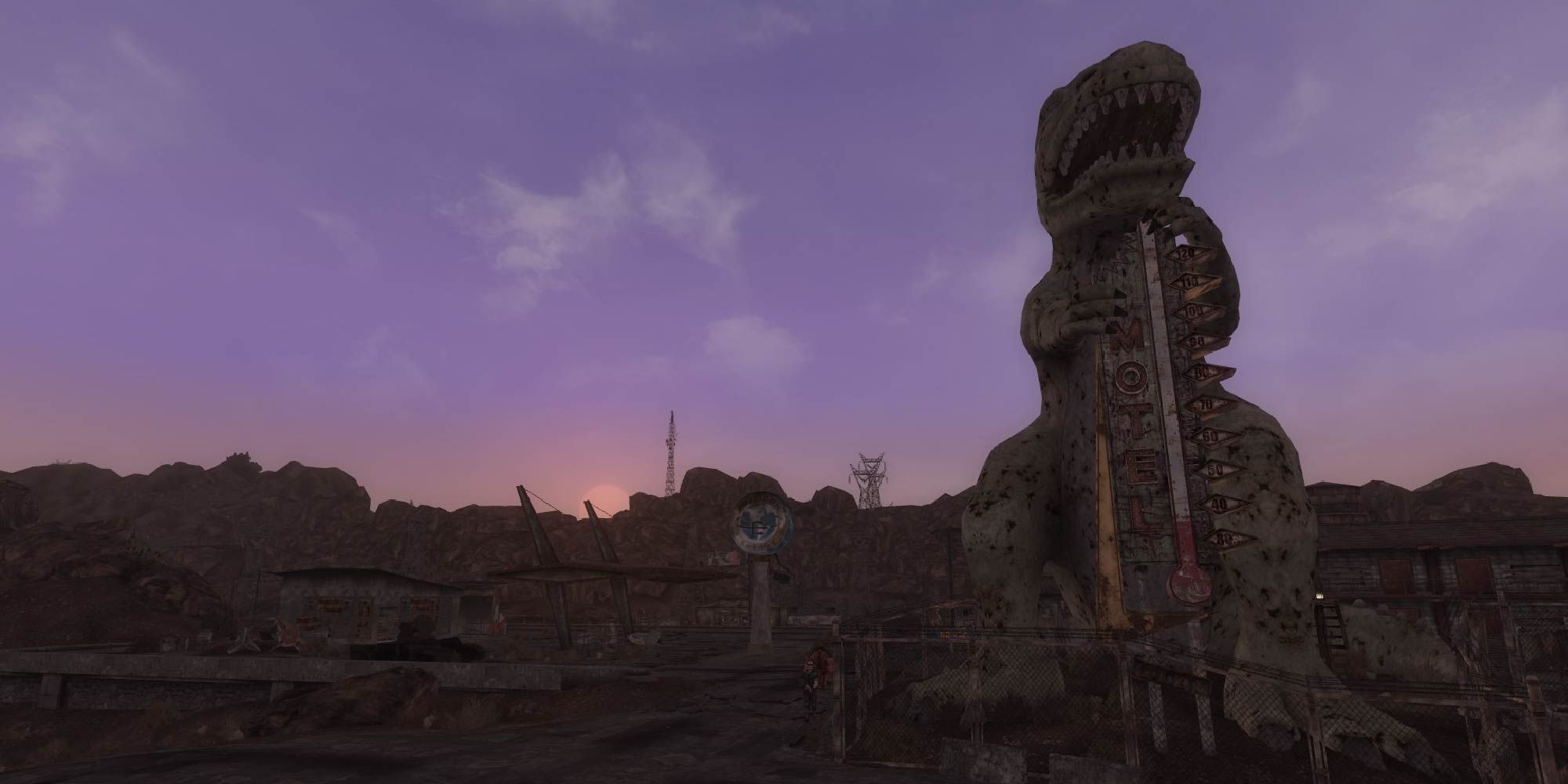 The town of Novac in New Vegas, with the dinosaur statue silhouetted against the sunset.