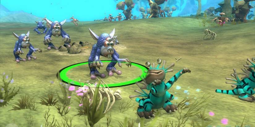In a field, three members of a race of blue aliens approach a green alien of a different race