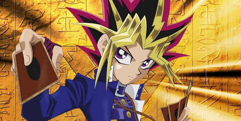 Yugi Mutou de Yu-Gi-Oh sur fond doré tenant un jeu de cartes
