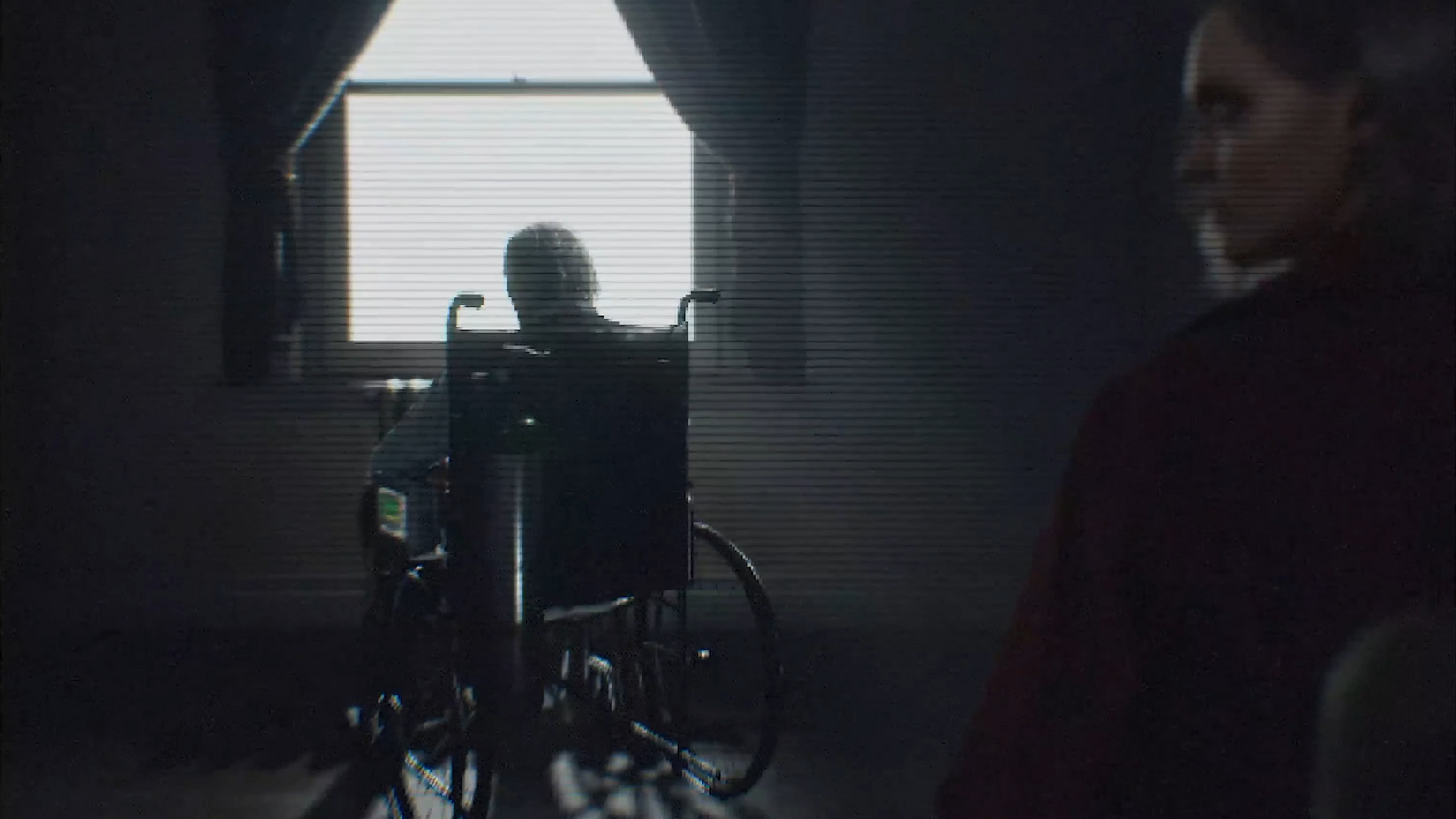 Ozwell E. Spencer sitting in his wheelchair facing a window, with interviewer Alyssa Aschroft sitting in the forefront.